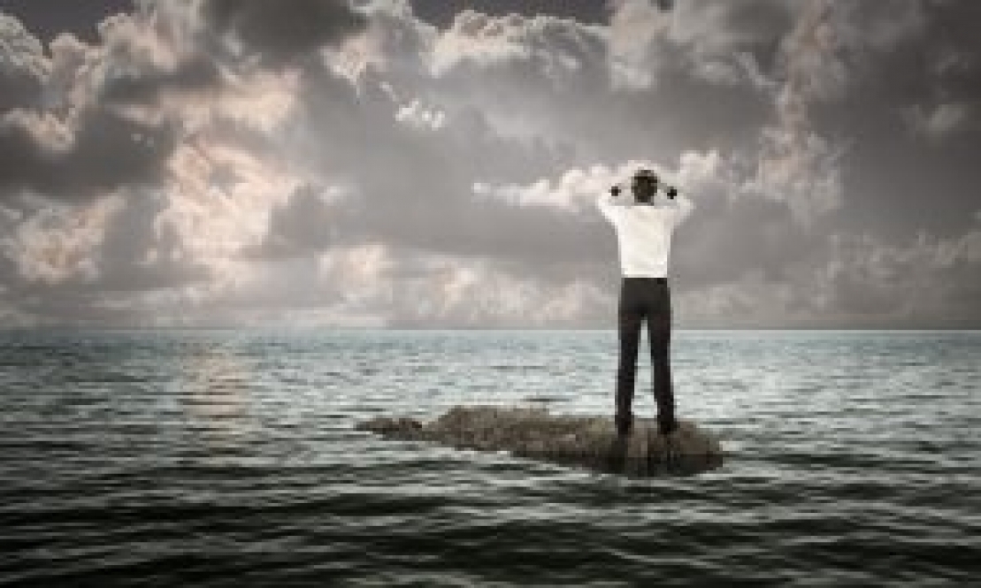 Man with hands on his head surrounded by the ocean