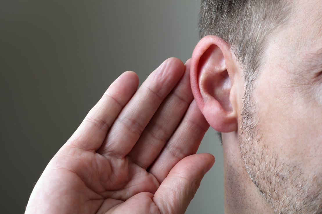 person cupping their ear to hear better